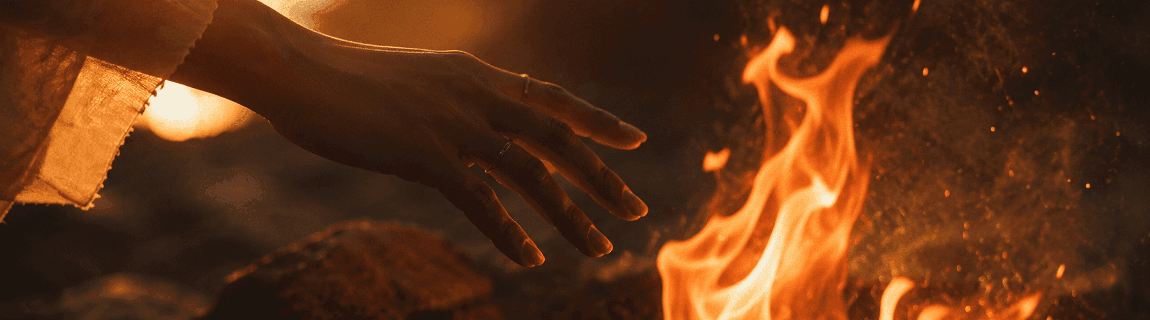 Photo - Een hand die naar felle vlammen reikt.