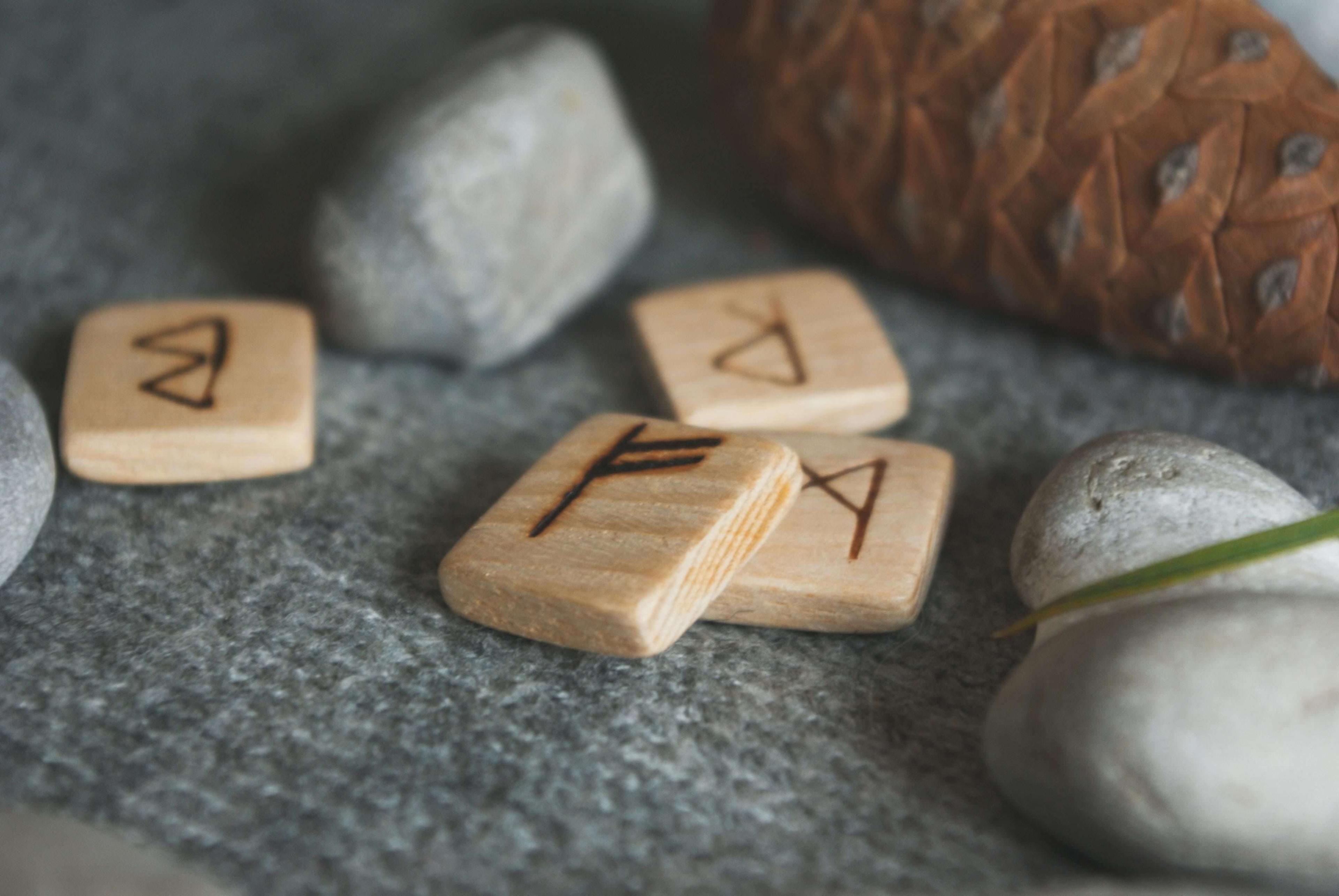 Runenstenen op een houten oppervlak, waar je een lezing kunt krijgen van een spirituele adviseur Photo - Runenstenen op een houten oppervlak, waar je een lezing kunt krijgen van een spirituele adviseur